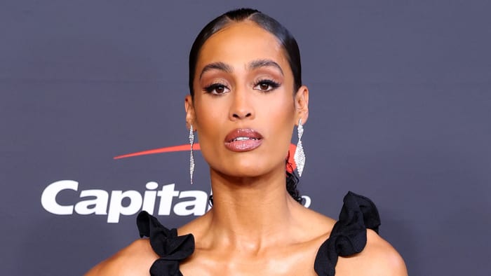 Skylar Diggins-Smith poses for the camera in a ruffled black dress.